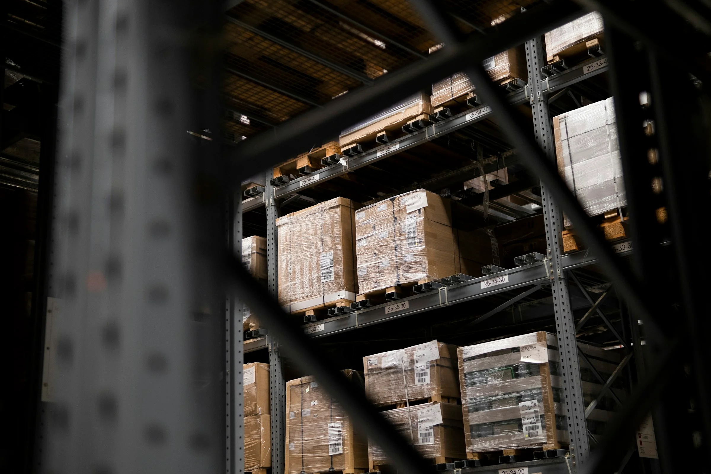 A warehouse aisle with stacked boxes and pallets