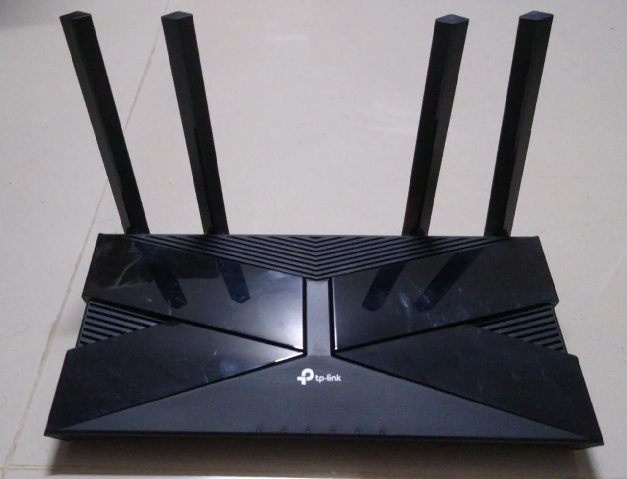 Black TP-Link router with four upright antennas seen from the front